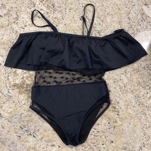 Black one piece swim suit with polka dot mesh mid-rise section, ruffle top